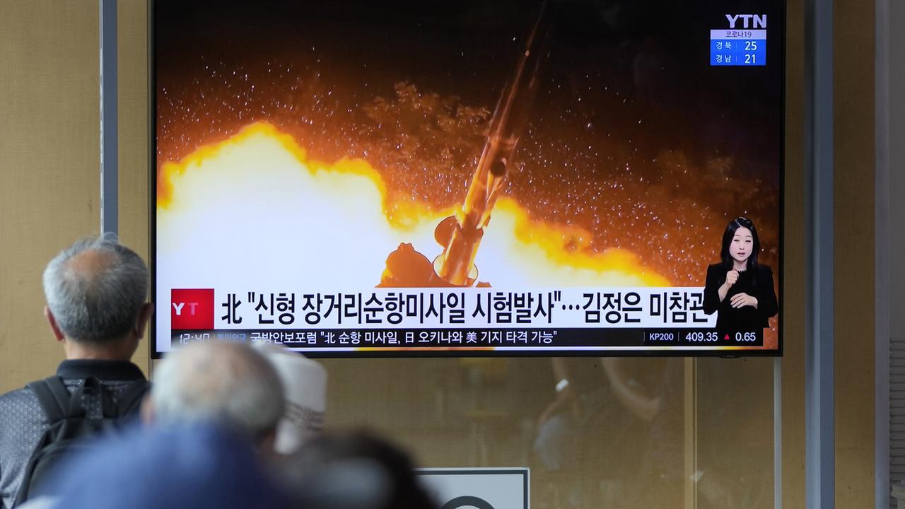A Séoul, en Corée du Sud, des personnes regardent un programme d'information qui montre une partie d'une photo nord-coréenne qui indique "Essais de missiles de croisière à longue portée de la Corée du Nord". [Keystone - AP Photo/Lee Jin-man]