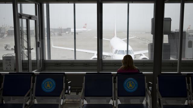 Une passagère attend son avion à l'aéroport de Genève. [Keystone - Laurent Gilliéron]