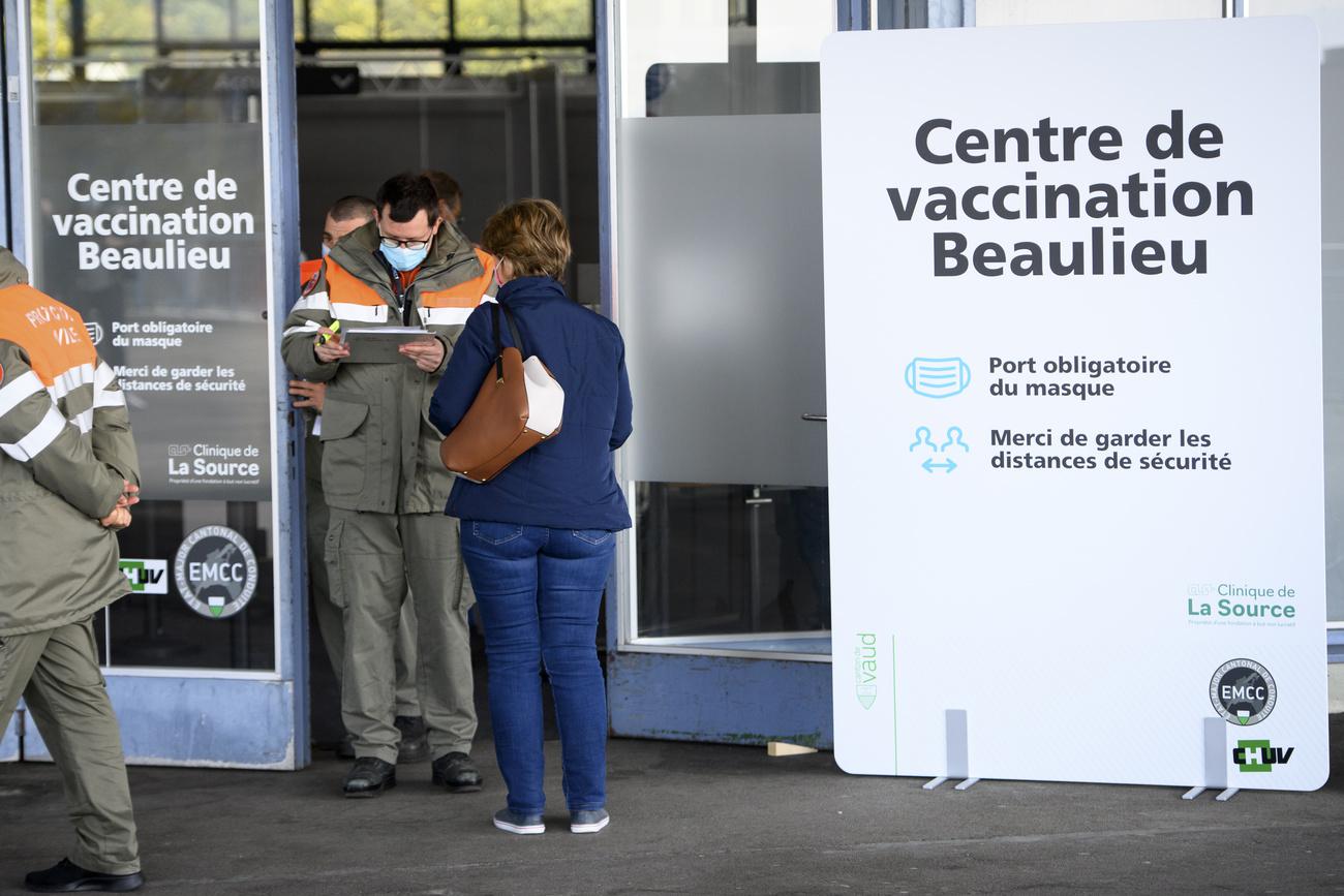 Des membres de la Protection civile accueillent les personnes à l'entrée du centre de vaccination de Beaulieu à Lausanne, le 19 avril 2021.