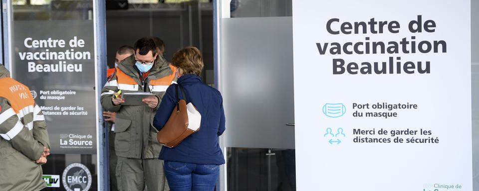 Des membres de la Protection civile accueillent les personnes à l'entrée du centre de vaccination de Beaulieu à Lausanne, le 19 avril 2021.