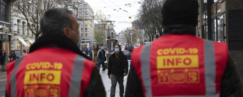 Depuis mi-décembre, des "Covid angels" patrouillent dans les rues basses de Genève pour faire respecter la règle du port du masque. [Keystone - Salvatore Di Nolfi]