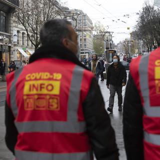 Depuis mi-décembre, des "Covid angels" patrouillent dans les rues basses de Genève pour faire respecter la règle du port du masque. [Keystone - Salvatore Di Nolfi]