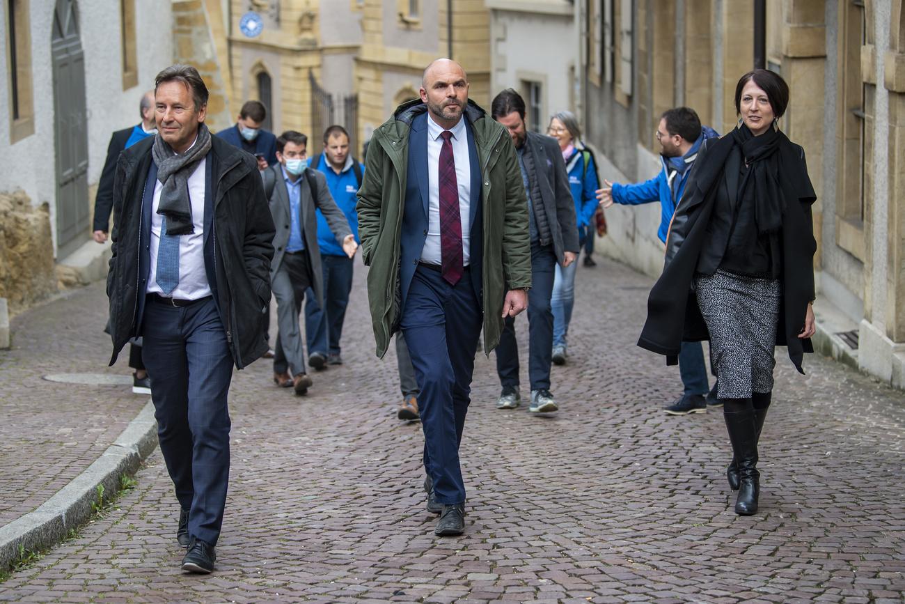 Les PLR Alain Ribaux, Laurent Favre et Crystel Graf arrivent au Château de Neuchâtel après leur succès lors de l'élection au Conseil d'Etat. [Keystone - Jean-Christophe Bott]