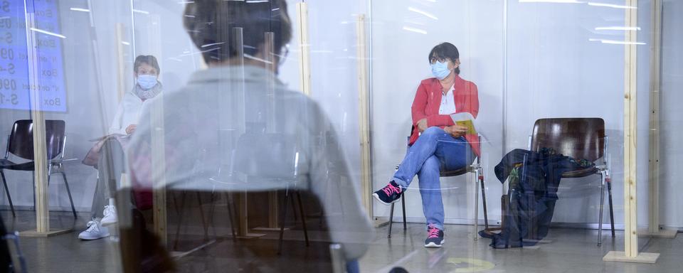 Une personne dans la zone d'attente post-vaccination Covid-19 au centre de vaccination de Montreux. [Keystone - Laurent Gilliéron]