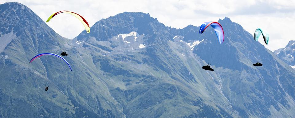 Mercredi 11 août: la finale de la Coupe du monde de parapente bat son plein à Disentis (GR). [Keystone - Gian Ehrenzeller]