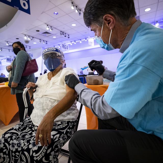 epa08990516 Honorina Rodriguez is vaccinated against COVID-19 at the Sharp Vaccination Site in La Mesa, East of San Diego, California, USA, 05 February 2021. The Sharp Vaccination Center receives an average of 1,000 patients every day. Honorina lost her husband and a son in-law to the virus. EPA/ETIENNE LAURENT [EPA via Keystone - Etienne Laurent]