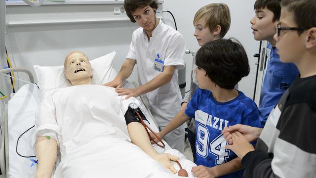 Un infirmier montre son métier en expliquant le fonctionnement d'un robot patient "Jean-Pierre" a des enfants lors d'un atelier de la Journée Oser tous les métiers ce jeudi 12 novembre 2015 dans les locaux du Centre des pratiques de la Haute Ecole de la Santé La Source à Lausanne. [KEYSTONE - LAURENT GILLIERON]