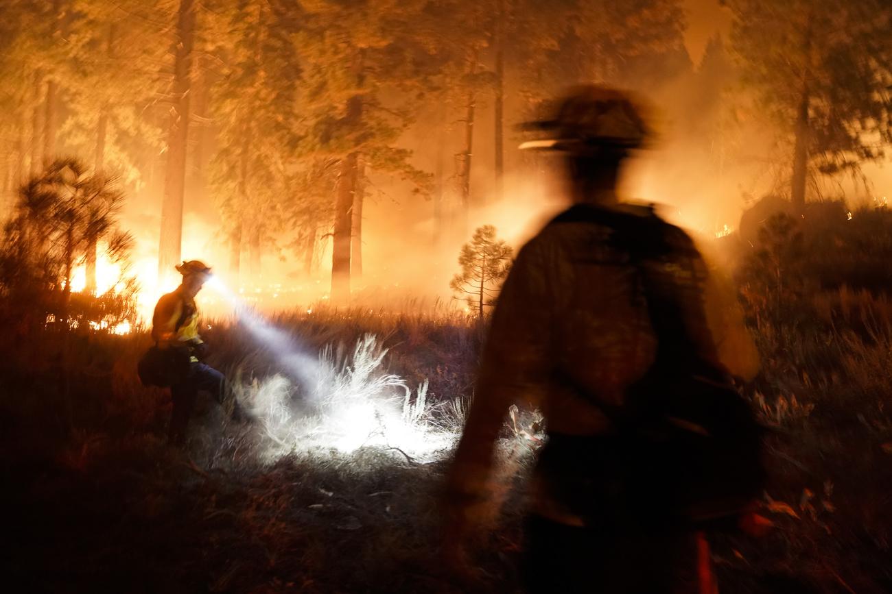 Les pompiers luttent depuis des jours contre le feu dans la région du lac Tahoe. [Keystone - AP Photo/Jae C. Hong]