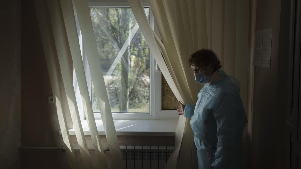 Une médecin montre les fenêtres brisées par les bombardements à l'intérieur d'un hôpital traitant des patients du Covid-19 dans la ville de Krasnohorivka, située sur la ligne de front, près de Donetsk. Ukraine, le 5 mai 2021. [Keystone/AP photo - Felipe Dana, File]