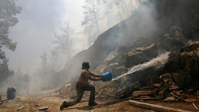 Secours et population ont combattu les flammes, parfois avec des moyens dérisoires. [AP/Keystone - Andreas Lazarou]