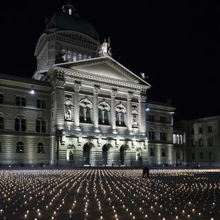 9200 bougies ont été allumées dimanche 21 février sur la Place fédérale à Berne, une par victime du Covid. [Keystone - EPA/Peter Schneider]