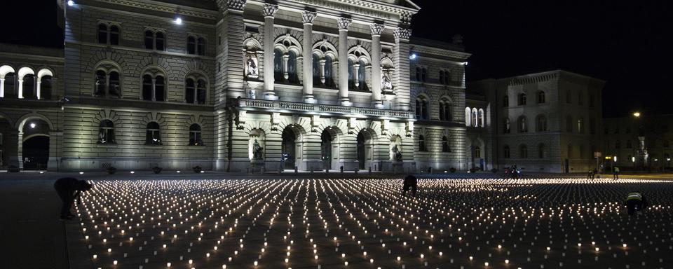 9200 bougies ont été allumées dimanche 21 février sur la Place fédérale à Berne, une par victime du Covid. [Keystone - EPA/Peter Schneider]