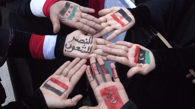 "La victoire aux peuples" écrit sur les mains de femmes avec les drapeaux de la Tunisie, Syrie, Yemen, Egypte et Libye. [Reuters - Mohamed al-Sayaghi]