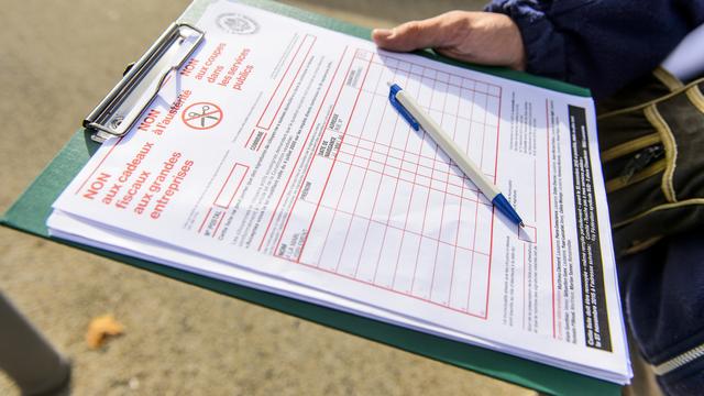 Les personnes qui récoltent des signatures contre rémunération pourraient être amendées à Neuchâtel. [Keystone - Jean-Christophe Bott]