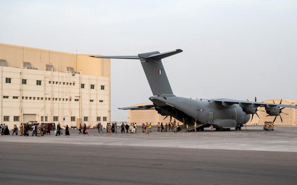Des personnes évacuées de Kaboul sortent d'un Airbus A400M, sur la base militaire française d'Al Dhafra, près d'Abu Dhabi, dans le cadre de l'opération "Apagan", le 23 août 2021. [AFP - Bertrand Guay]