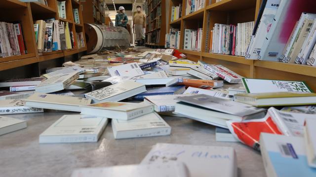 Des livres tombés des rayonnages d'une bibliothèque dans la ville de Koriyama, dans la préfecture de Fukushima ébranlée par un séisme, le 14 février 2021. [AFP - Ken Satomi]