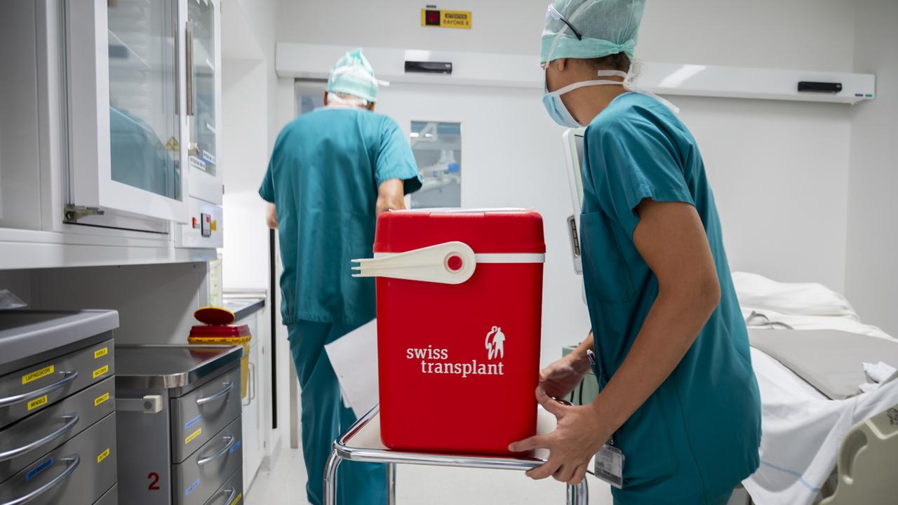 Un rein est transporté dans une glacière lors d'une transplantation d'organe dans un bloc opératoire au CHUV. [Keystone - Leandre Duggan]