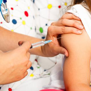 Gros plan sur le bras d'un enfant en train de se faire vacciner. [Depositphotos - Barabasa]