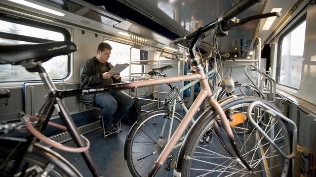 Un homme voyage dans le compartiment destiné au transport des vélos dans un train CFF. [Keystone - Gaetan Bally]