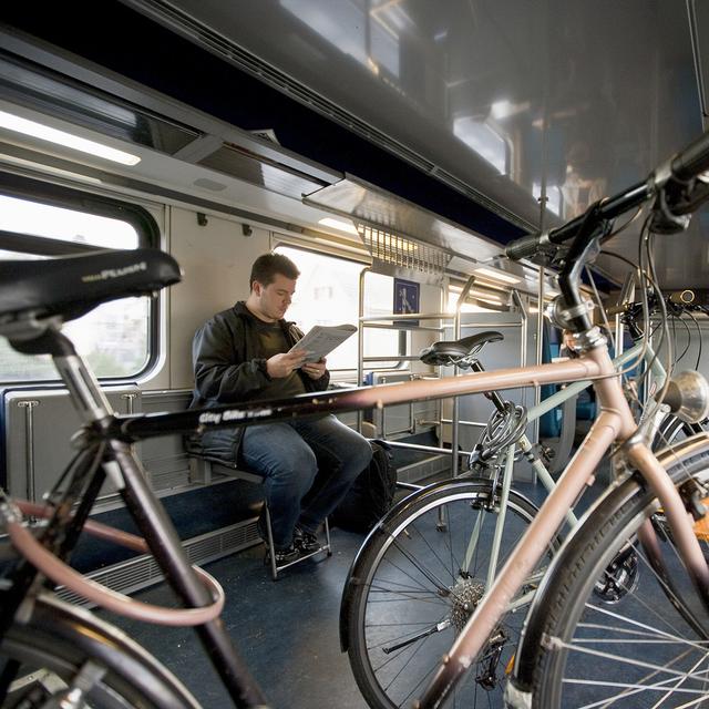 Un homme voyage dans le compartiment destiné au transport des vélos dans un train CFF. [Keystone - Gaetan Bally]