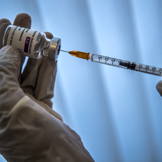 Une personne prépare un vaccin contre le Covid, le 26 février 2021. [EPA/Keystone - Christophe Petit-Tesson]
