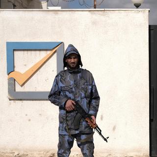 Un agent de sécurité se tient devant le bâtiment de la Haute Commission électorale nationale à Benghazi (Libye). [Reuters - Esam Omran Al-Fetori]