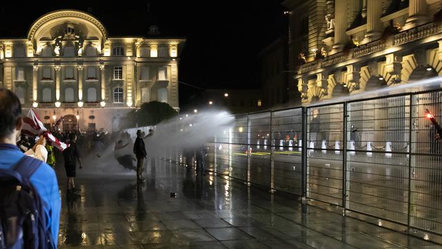 Pour protéger le Palais fédéral des débordements, la police a eu recours à un canon à eau. Berne, le 16 septembre 2021. [Keystone - Peter Klaunzer]