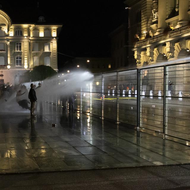 Pour protéger le Palais fédéral des débordements, la police a eu recours à un canon à eau. Berne, le 16 septembre 2021. [Keystone - Peter Klaunzer]