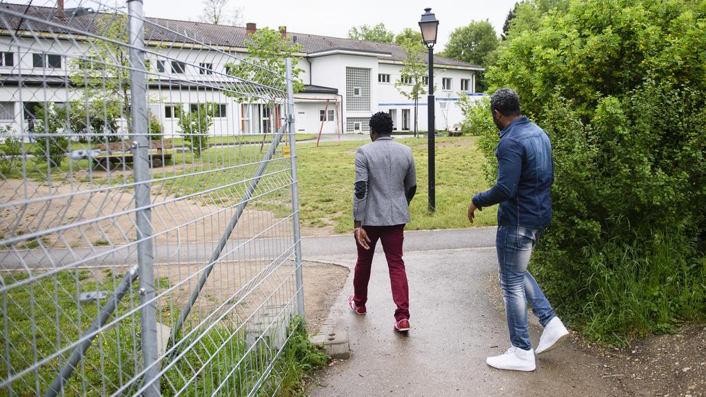 Deux demandeurs d'asile photographiés devant le centre d'asile fédéral de Perreux lors d'une visite de presse le mercredi 11 mai 2016. [Keystone - Manuel Lopez]