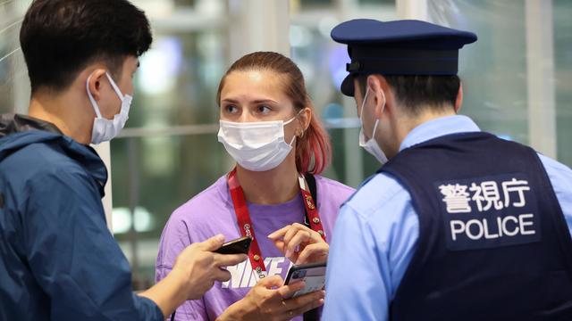 Krystsina Tsimanouskaya parle avec la police japonaise à l'aéroport de Tokyo, le 1 août 2021. [Reuters - Issei Kato]