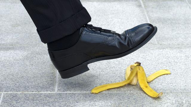 Gros plan sur un pied qui s'apprête à glisser su rune peau de banane. [Depositphotos - david_franklin]