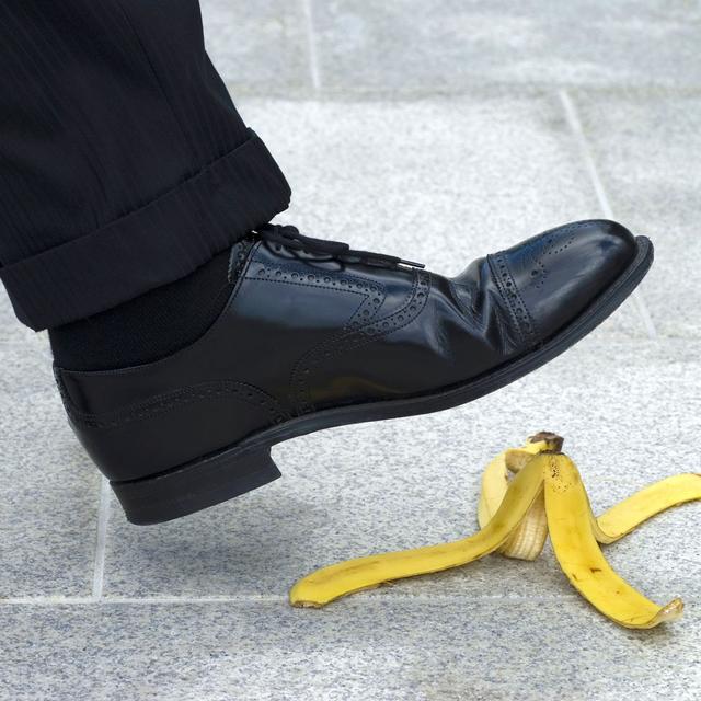 Gros plan sur un pied qui s'apprête à glisser su rune peau de banane. [Depositphotos - david_franklin]