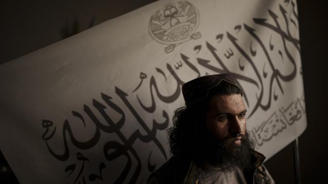 Le chef de la police talibane du district, Shirullah Badri, se tient devant un drapeau taliban. Kaboul, le 20 septembre 2021. [Keystone/AP photo - Felipe Dana]