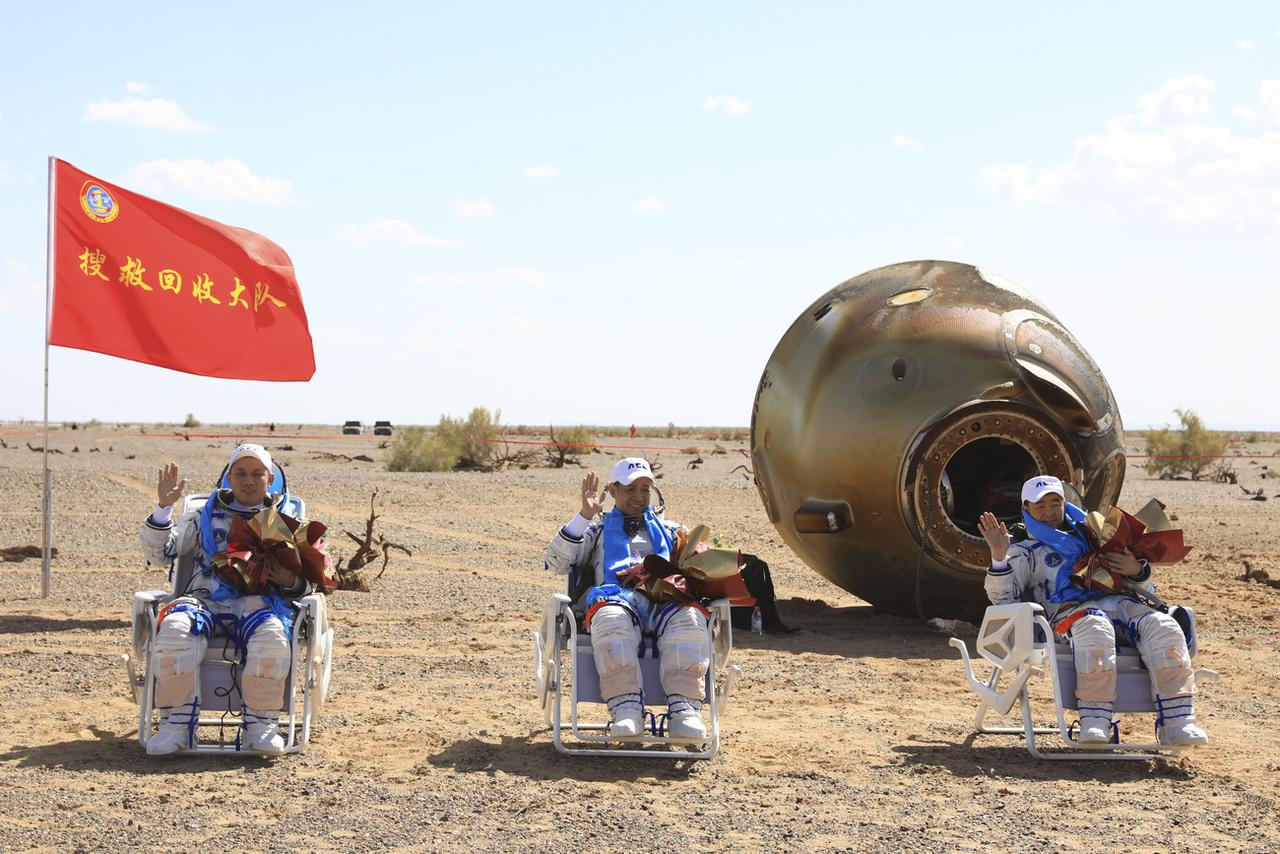 De gauche à droite, les astronautes chinois Tang Hongbo, Nie Haisheng et Liu Boming après l'atterrissage de leur capsule dans le désert de Gobi. [KEYSTONE - Xinhua / AP]