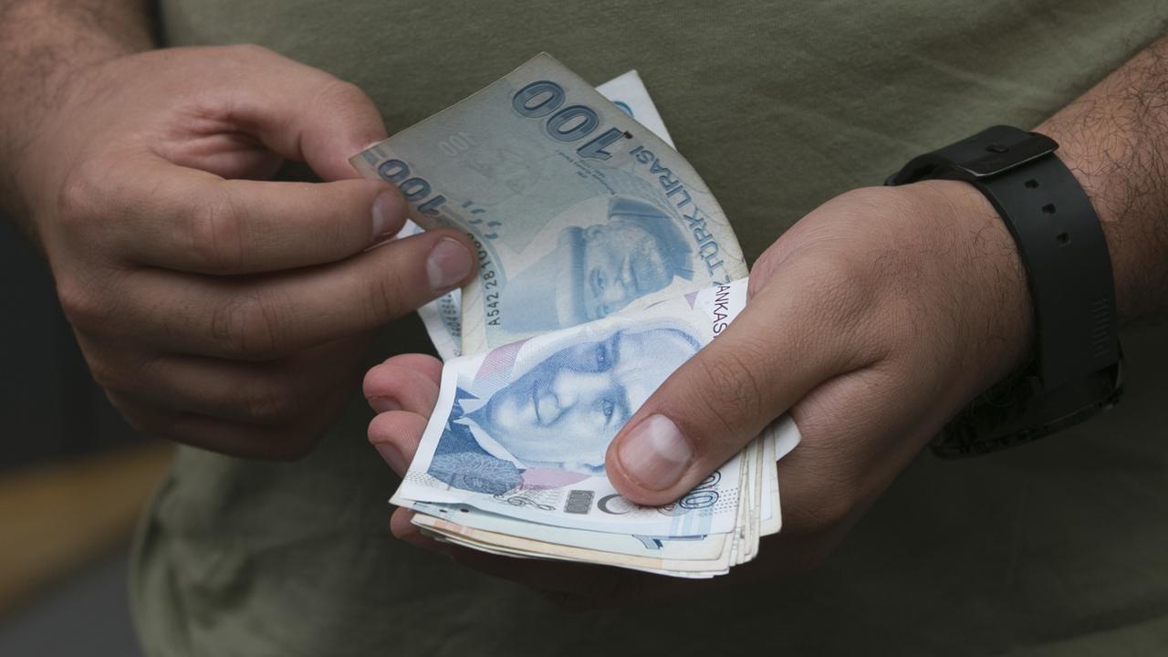 Un homme compte son argent à Istanbul, alors que la livre turque est sous pression. [AP - Petros Giannakouris]