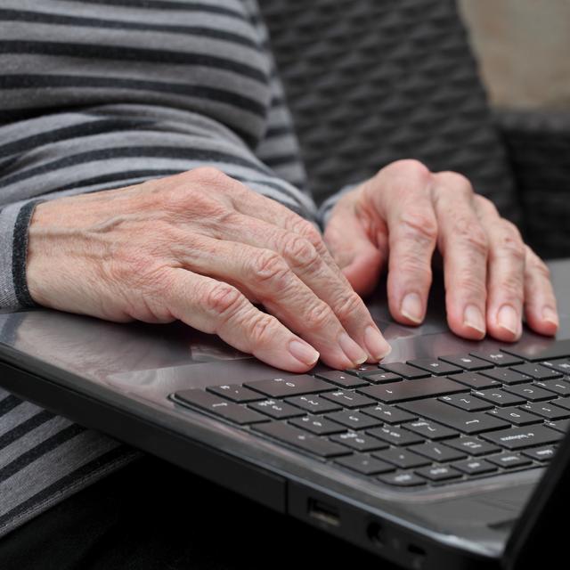 Mains d'une personne âgée pianotant sur l'ordinateur. [Depositphotos - simazoran]