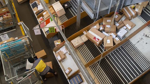 Un employe de La Poste trie les colis au centre colis Daillens de la Poste. [Keystone - Salvatore Di Nolfi]