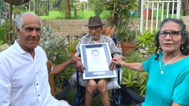 Emilio Flores Marquez pose avec des membres de sa famille et son diplôme. [Guiness World Records]