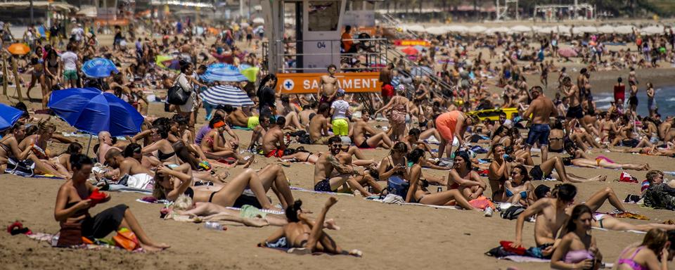 Vendredi 9 juillet: une plage bondée en Espagne, au moment où la France met en garde ses ressortissants contre les risques sanitaires de vacances dans la péninsule ibérique. [AP/Keystone - Joan Mateu]