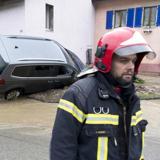 Pompier en intervention lors d'inondations à Dombresson, dans le Val-de-Ruz (NE), 22.06.2019. [Keystone - Laurent Gilliéron]