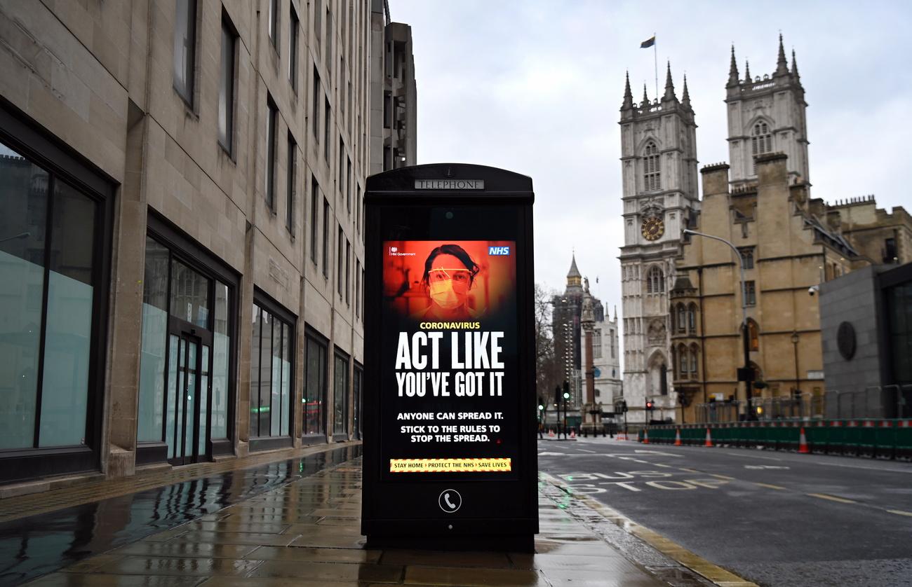 "Coronavirus – Agissez comme si vous l'aviez", demande cette affiche à un arrêt de bus. Londres, le 20 janvier 2021. [Keystone/epa - Andy Rain]