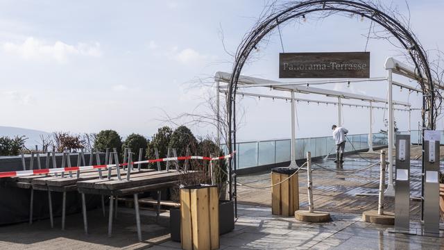 Une personne nettoie une terrasse fermée, à Uetliberg dans le canton de Zurich, le 10 mars 2021. [Keystone - Ennio Leanza]