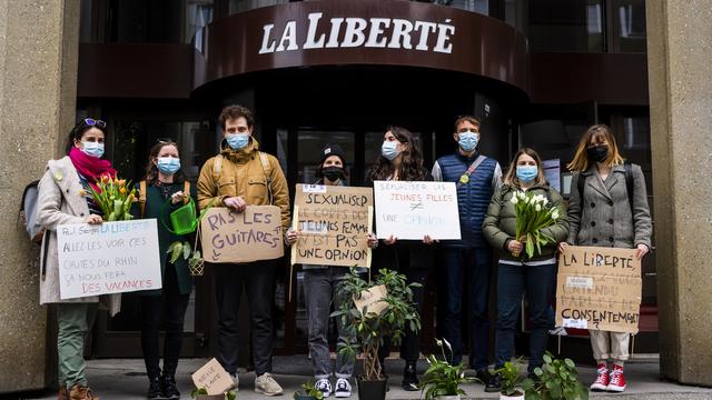 Des militantes et militants manifestent devant les locaux de La Liberté à Fribourg, le 13 avril 2021. [KEYSTONE - Jean-Christophe Bott]