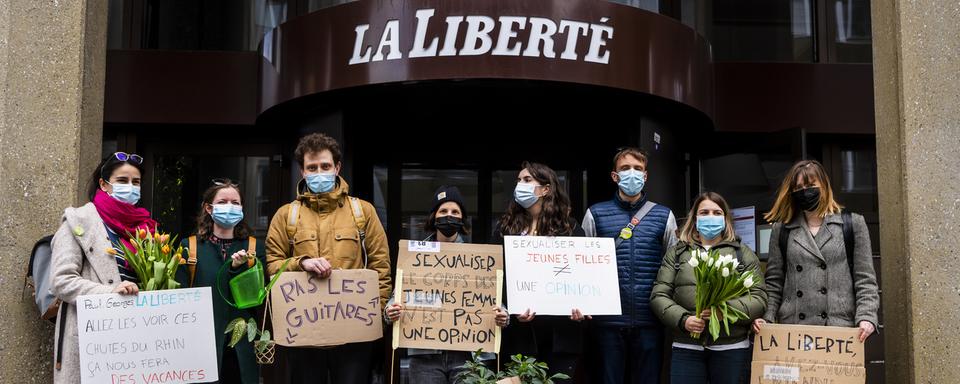 Des militantes et militants manifestent devant les locaux de La Liberté à Fribourg, le 13 avril 2021. [KEYSTONE - Jean-Christophe Bott]