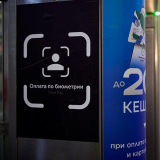 Un sticker est collé sur un portique de contrôle de billets équipé d'un système de paiement par reconnaissance faciale à la station de métro Turgenevskaya, à Moscou. [AFP - Natalia Kolesnikova]