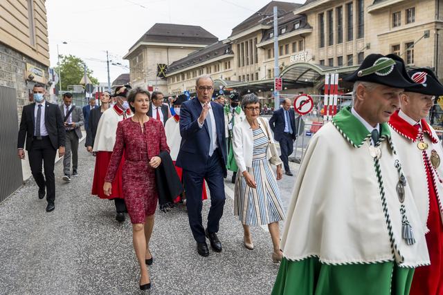 Guy Parmelin se déplace dans Lausanne, entouré de Simonetta Sommaruga et de son épouse Caroline. [Keystone - Jean-Christophe Bott]