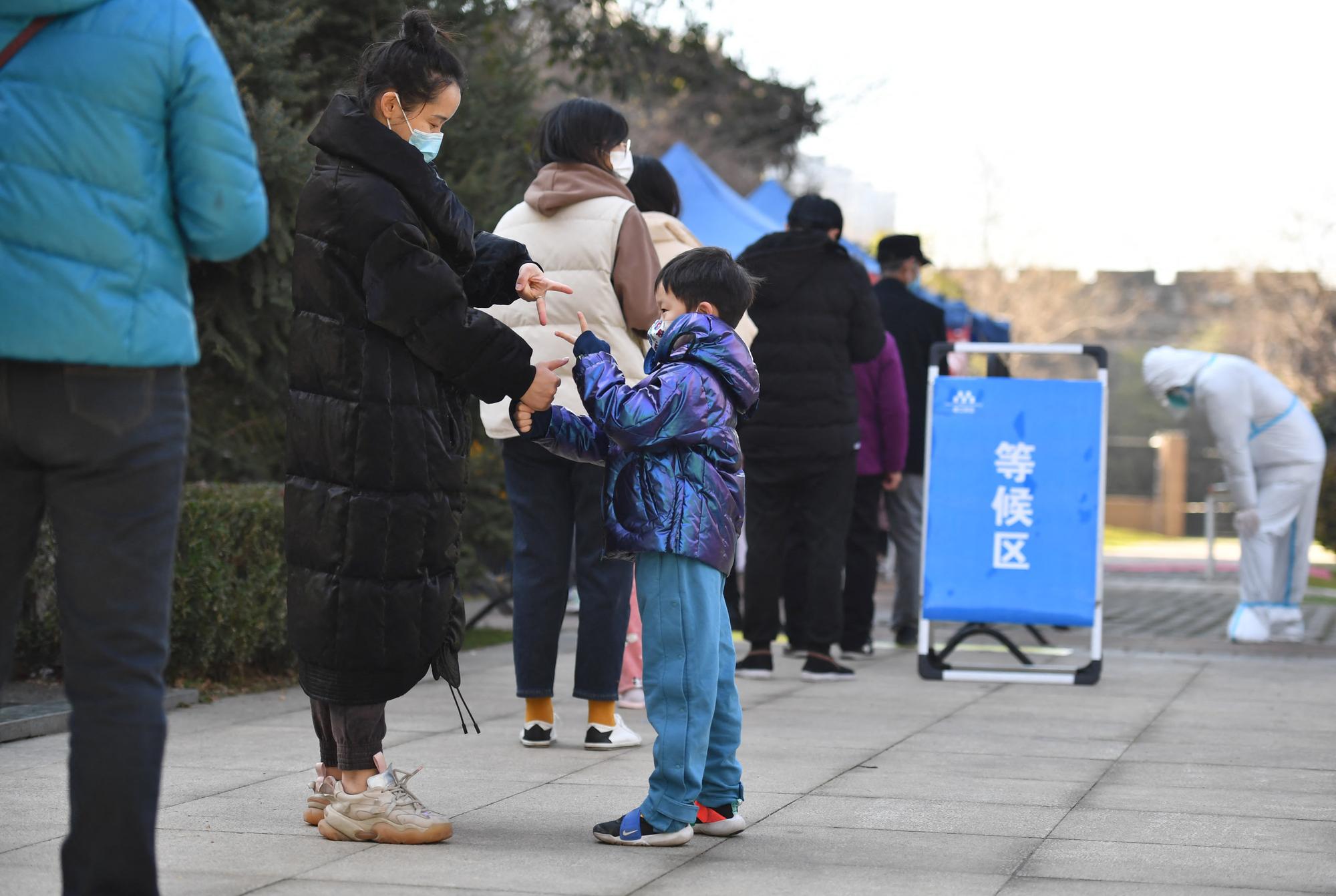 Des habitants de la ville de Xi'an attendent pour se faire dépister contre le Covid-19. [XINHUA VIA AFP - SHAO RUI]