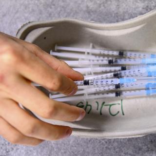 Des seringues contenant le vaccin contre le Covid-10 de la firme Moderna. [Keystone - Laurent Gillieron]
