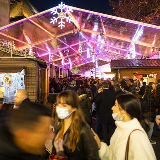 La foule entre les chalets la place St-François à Lausanne, à l'ouverture du marché Bô Noël. [Keystone - Jean-Christophe Bott]