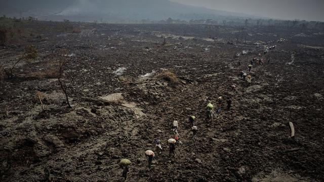 Des personnes transportent leurs biens, alors qu'elles évacuent la région recouverte par les cendres de l'éruption du volcan Nyiragongo près de Goma, le 25 mai 2021. [Reuters - Hugh Kinsella Cunningham/Save the Children]